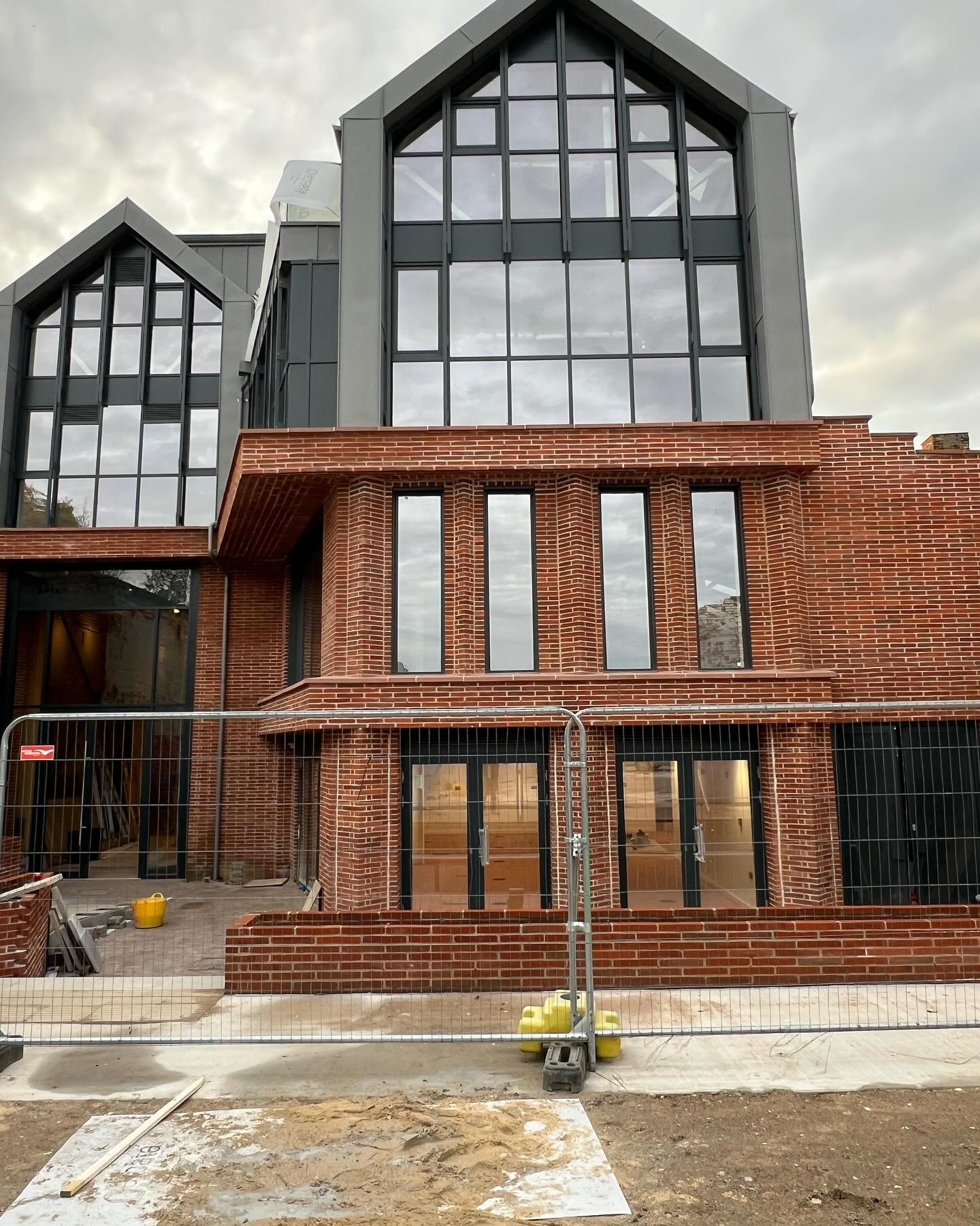 A brick and glazed building during construction